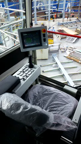 La cabina di comando: il pannello con la schermata del carousel accesa, il joystick e la pulsantiera, il sedile ancora avvolto nel cellophane; fuori dal vetro, il piano del carousel con i pezzi da montare.