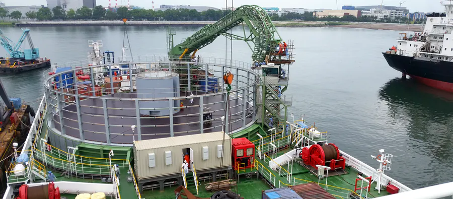 Il ponte della nave Ulisse: il carousel circolare che contiene il cavo, la gru di guida ad arco, la cabina di comando e i verricelli rossi.