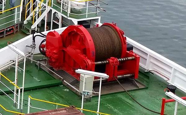 Un verricello rosso sul ponte della nave Ulisse, con il tamburo avvolto di fune.
